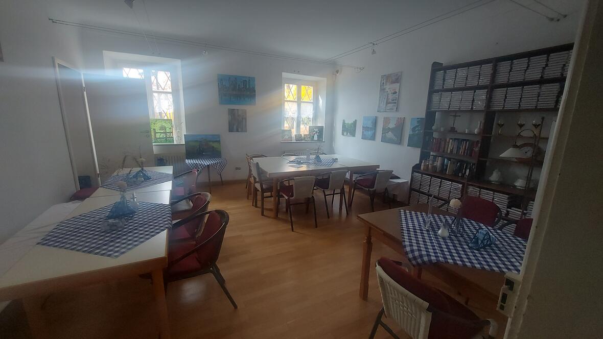 Raum 3 im Pfarrhaus Oberelchingen mit Tischen, Stühlen und dekorierten Tischdecken.