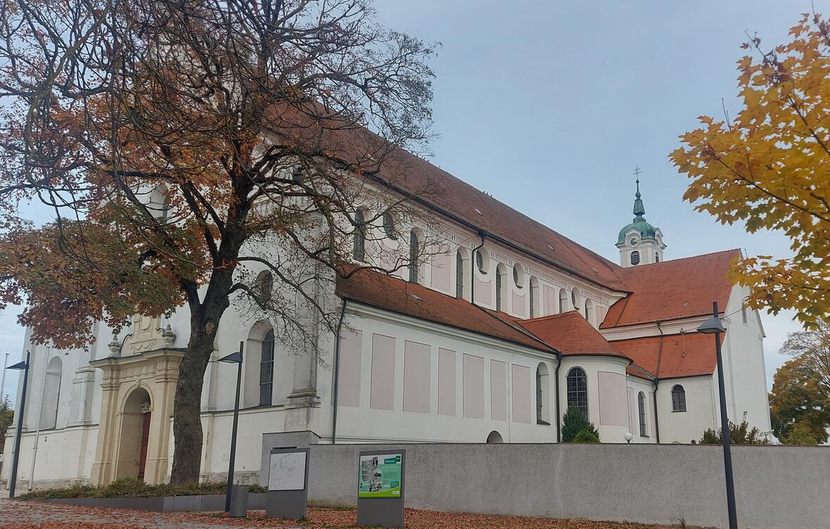 Klosterkirche St. Peter und Paul in Oberelchingen mit herbstlichen Bäumen im Vordergrund.